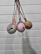 Set of four colorful dummy holders hanging against a light wooden background