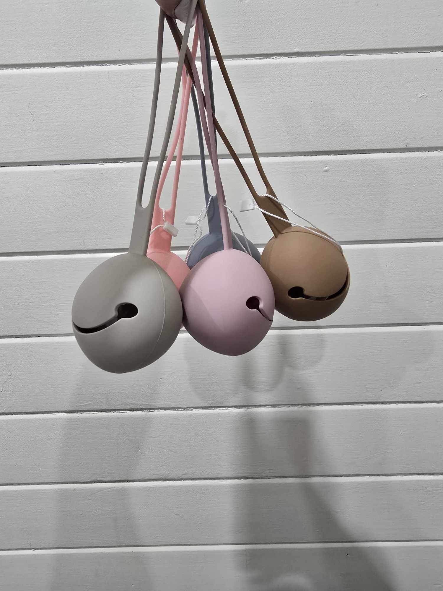 Set of four colorful dummy holders hanging against a light wooden background