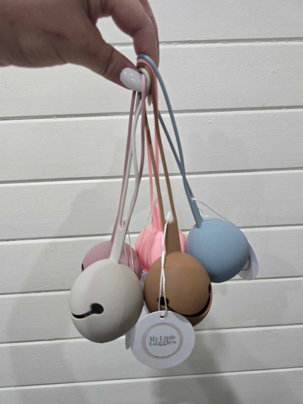 Set of colorful dummy holders held by a hand on a light wooden surface