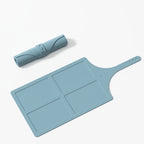 Blue silicone cutting board with handle on a white background