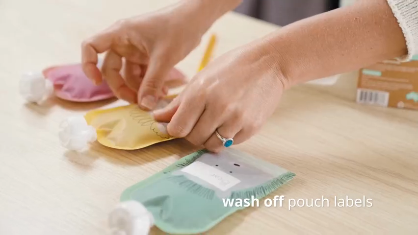 Hands removing labels from pouches on a wooden surface