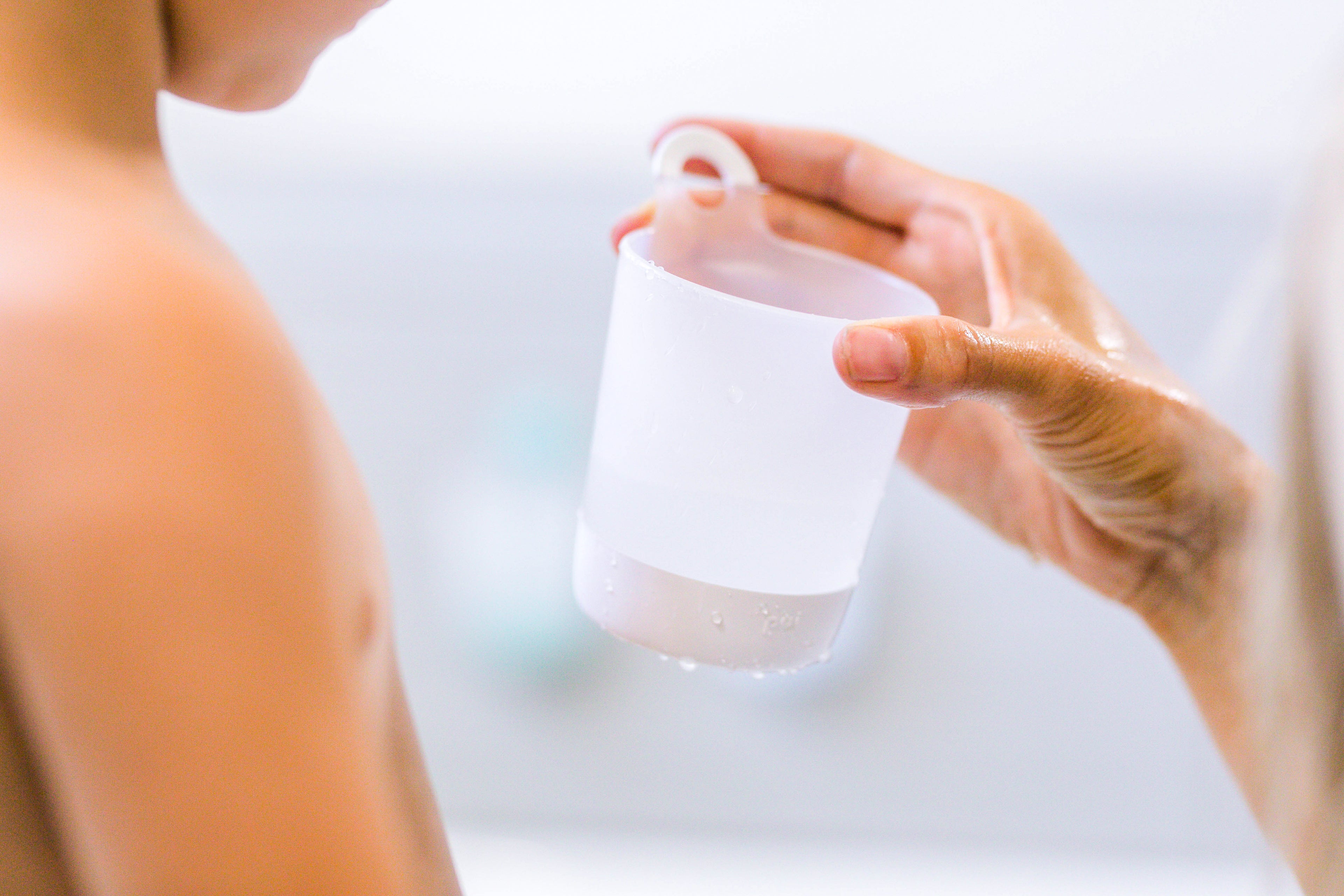 Person holding a hangable kids cups against a blurred background
