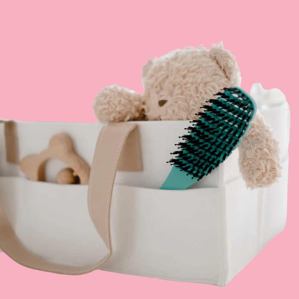 Teddy bear with a brush in a white container on a pink background