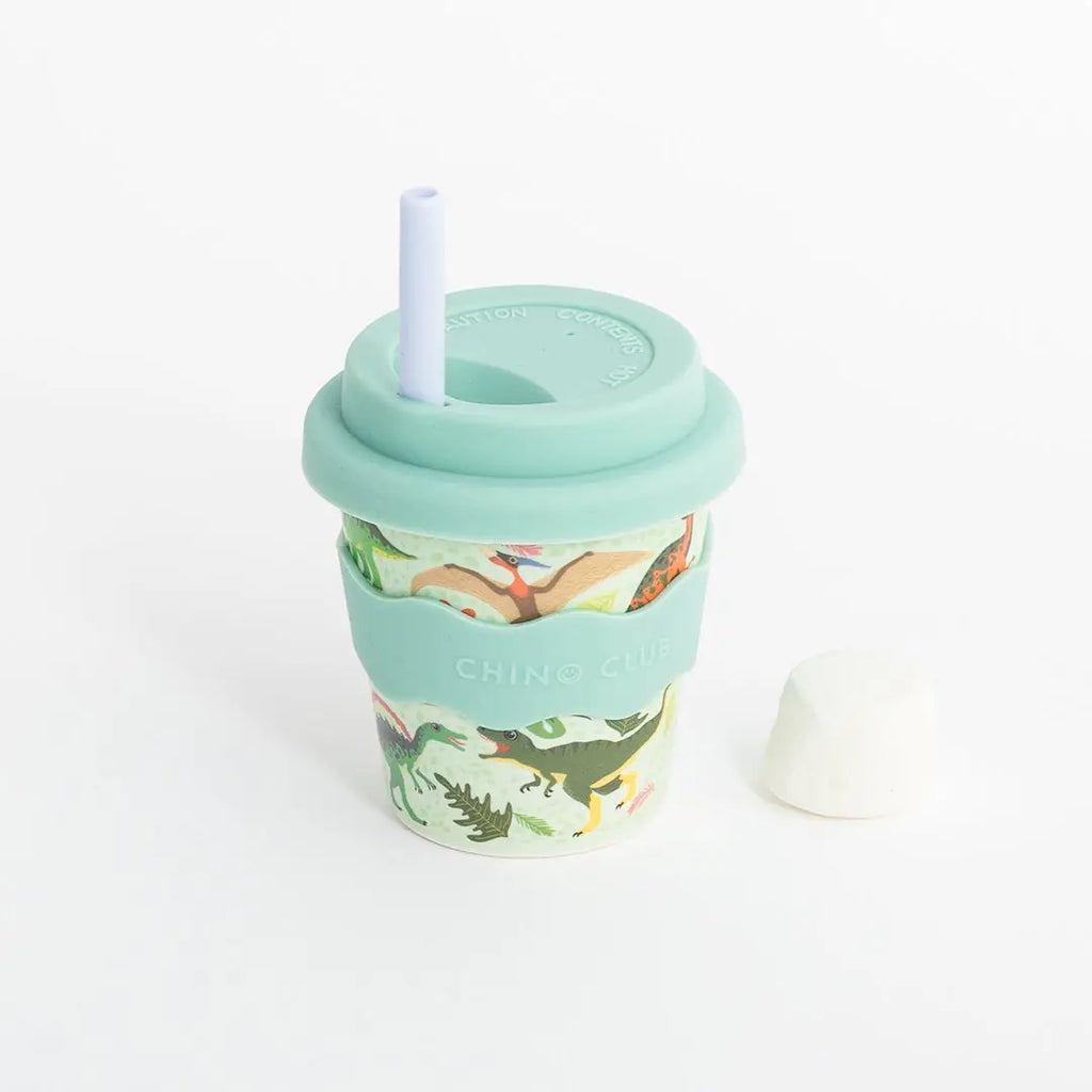 Reusable cup with dinosaur design and straw on a white background