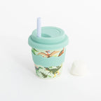 Reusable cup with dinosaur design and straw on a white background