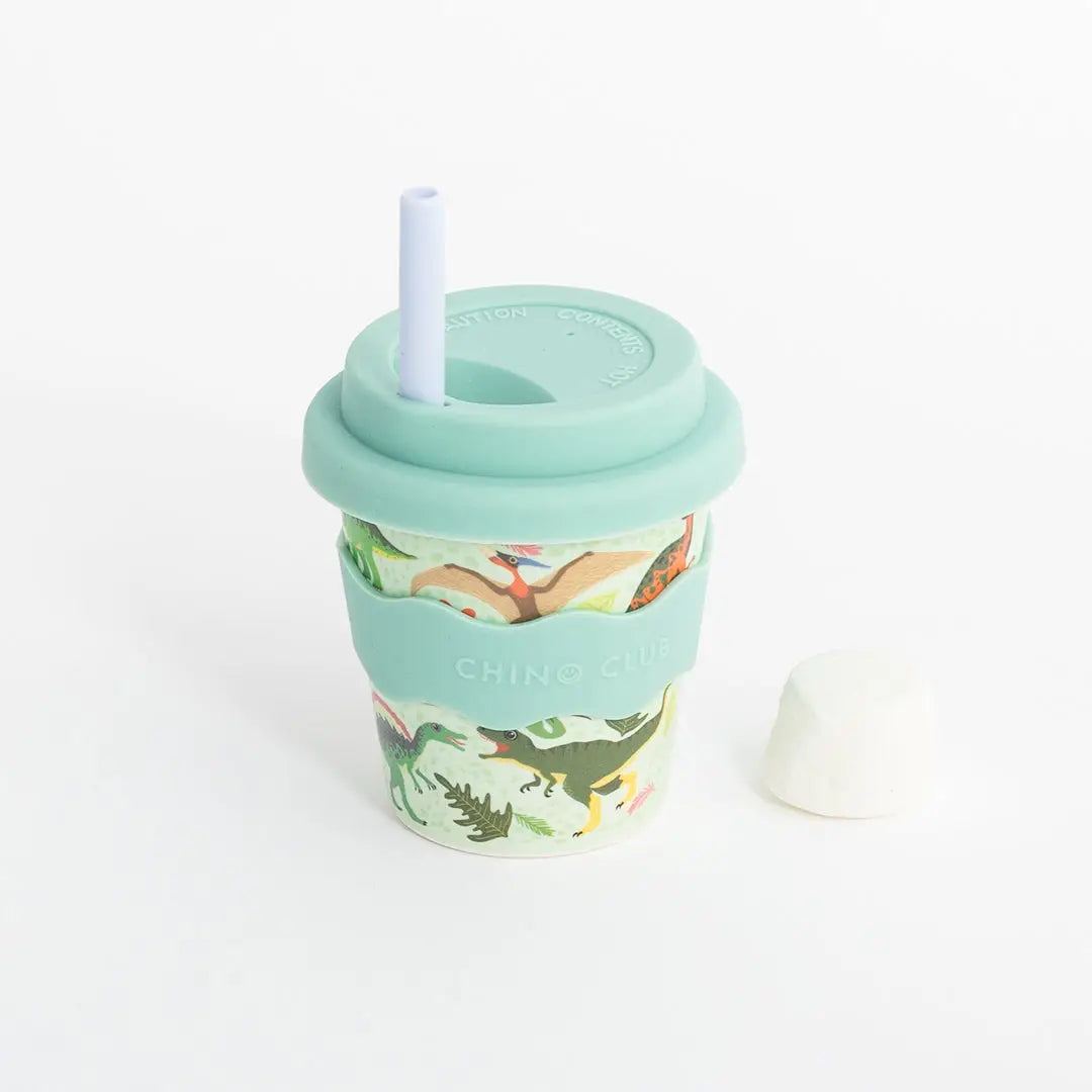 Reusable cup with dinosaur design and straw on a white background
