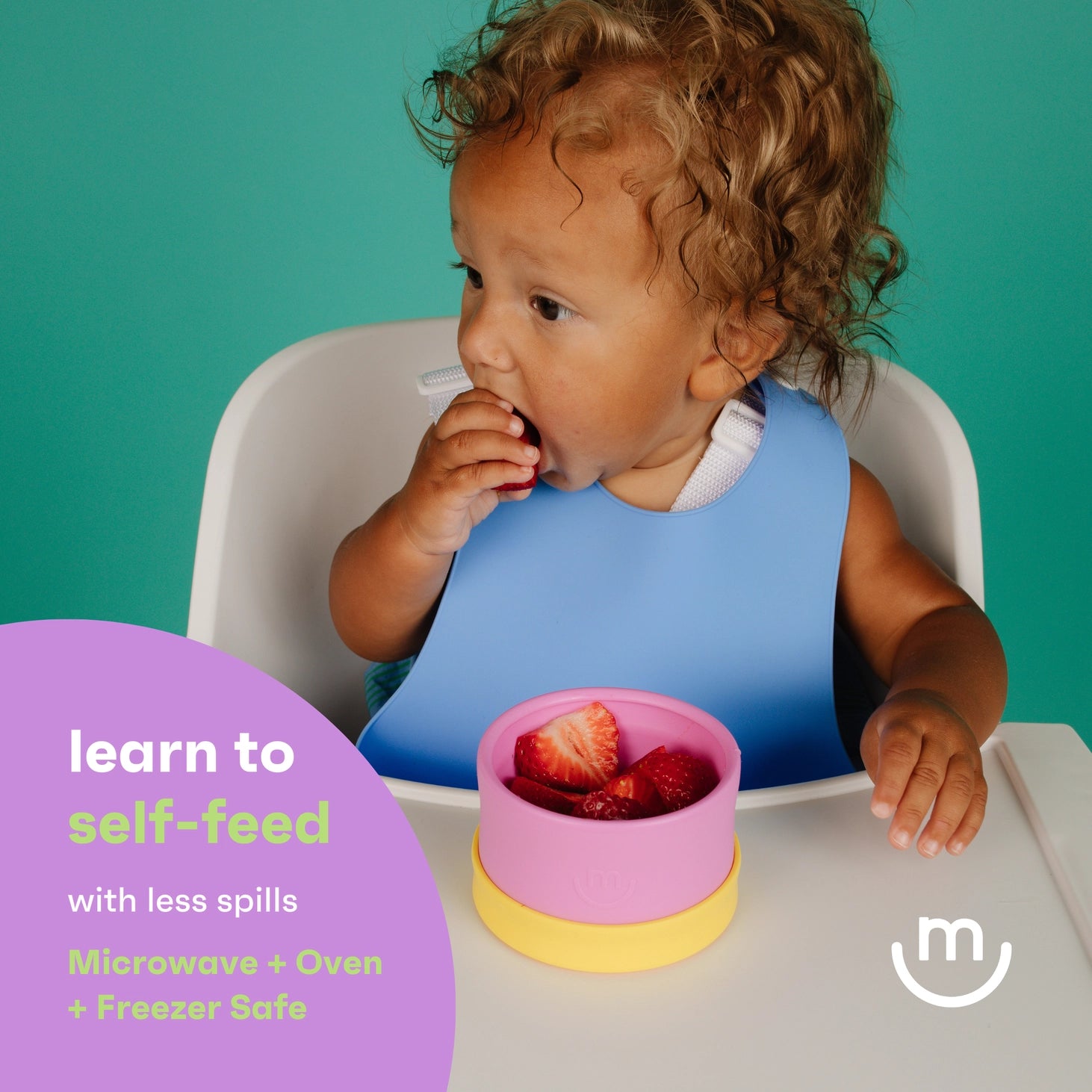Child in a high chair with a pink bowl of fruit, learn to self-feed