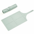 Mint green silicone rolling pin and cutting board set on a white background