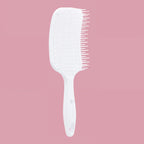 White hairbrush on a pink background