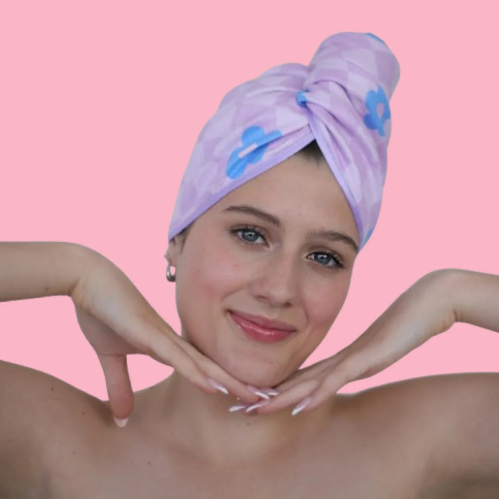 Woman wearing a purple towel with blue flowers on a pink background
