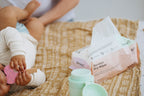 Bamboo dry wipes on a textured surface with a child playing nearby.