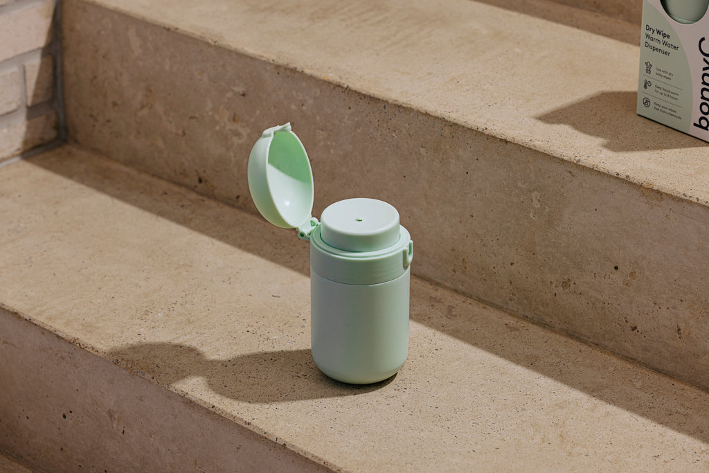 Warm water dispenser with a lid on concrete steps