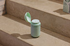Warm water dispenser with a lid on concrete steps