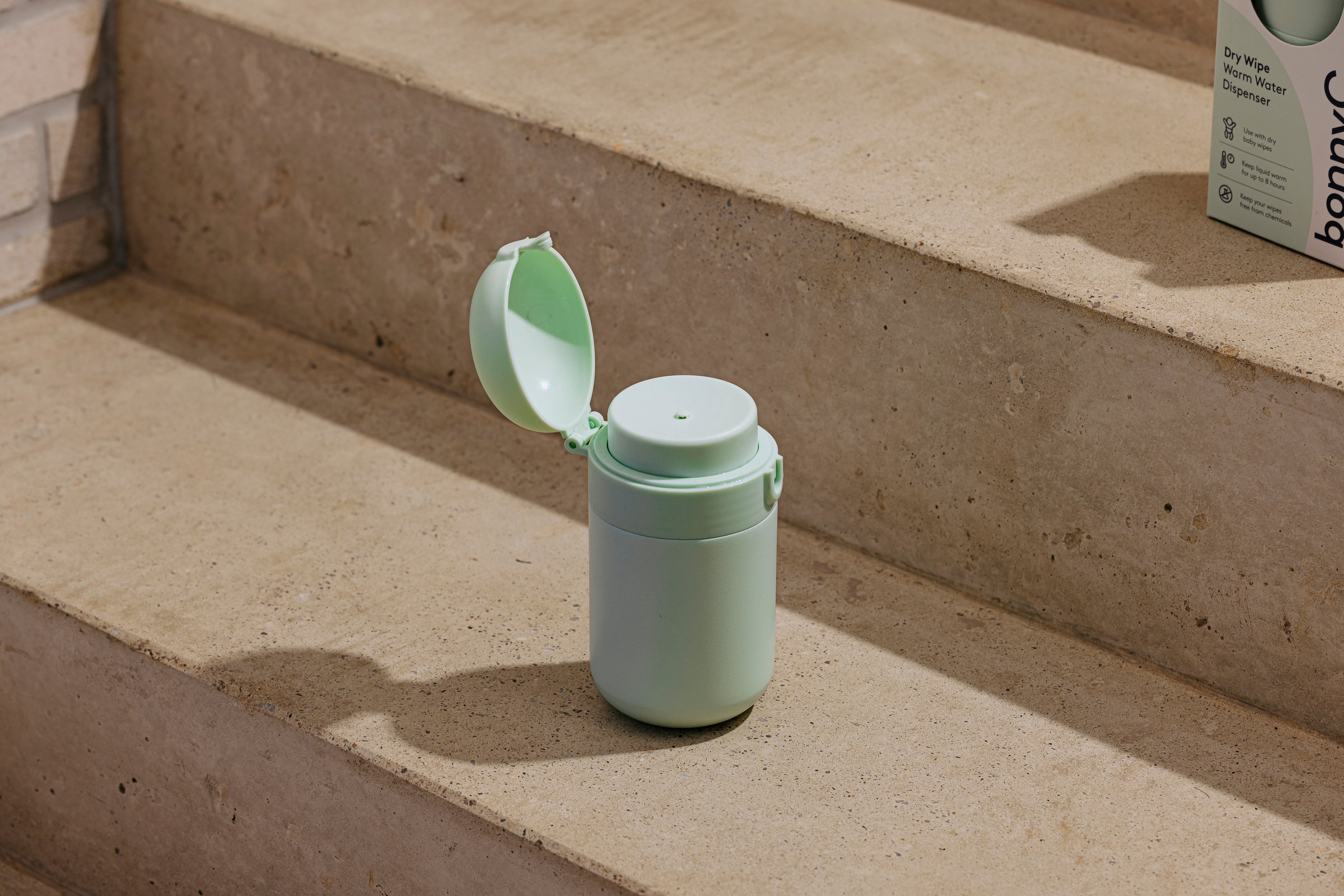 Warm water dispenser with a lid on concrete steps