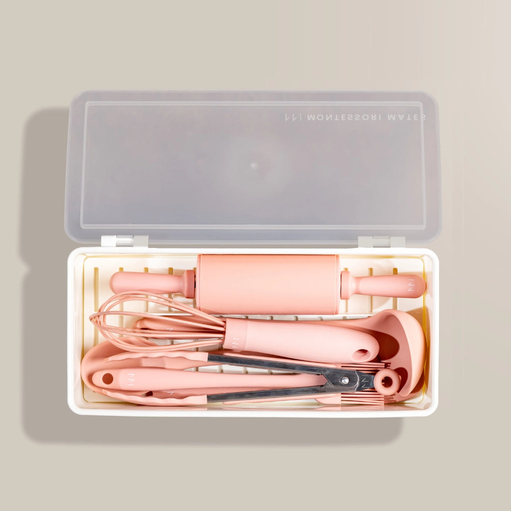 Set of pink hair styling tools in a clear plastic case on a beige background