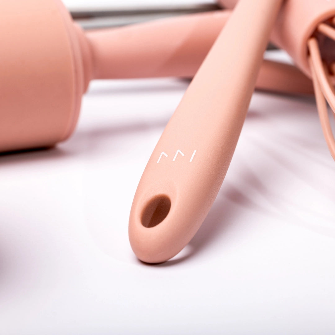 Close-up of a pink silicone tool with a brand logo on a light background
