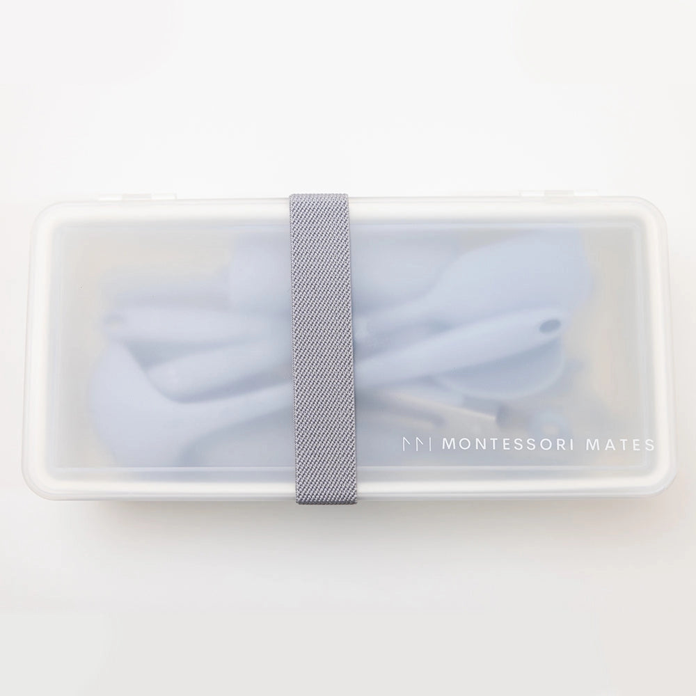 Rectangular container with light blue fabric and gray strap on a white background, featuring 'Montessori Mates' branding.
