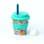 Reusable cup with animal pattern and turquoise lid and straw on a white background